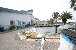 耐病性育種等実験施設の建設地付近の現況(既存の水槽と飼育実験棟(左)) 耐病性育種等実験施設の建設地付近の現況(既存の水槽と飼育実験棟(左))