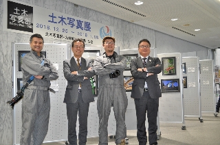 (鹿嶋)写真パネルの前でデミマツらとポーズをとる伊勢田局長(中央左)